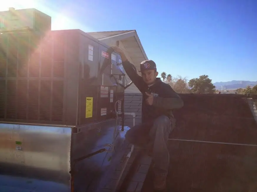 HVAC technician performing Air Duct Cleaning on a rooftop unit in Valley